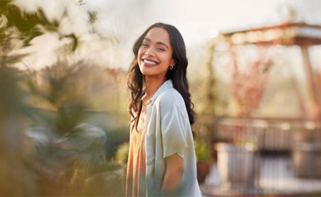 A woman smiling while enjoying her time outside in dramatic lighting