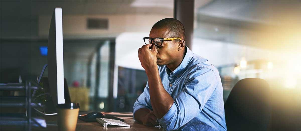 A man sitting at the computer and struggling to focus.