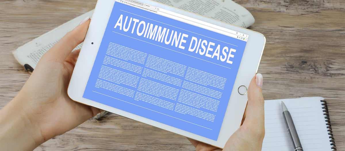 Display of an article titled "Autoimmune Disease" on an electronic tablet being  above a desk with paper note pads.