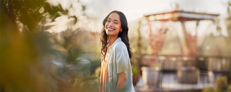 A woman smiling while enjoying her time outside in dramatic lighting